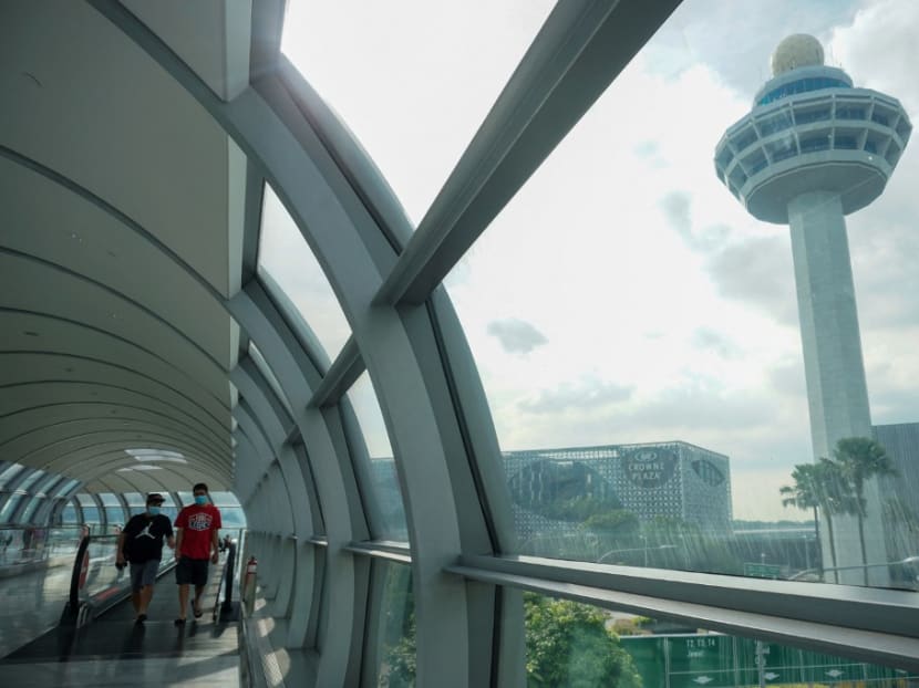People walk along the link bridge to a terminal at Changi Airport in Singapore on Nov 18, 2021.