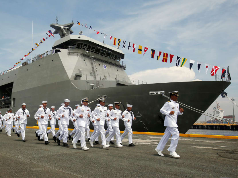 Philippine Navy personnel jog past a Strategic Sealift Vessel BRP Tarlac LD601 vessel. Photo: Reuters
