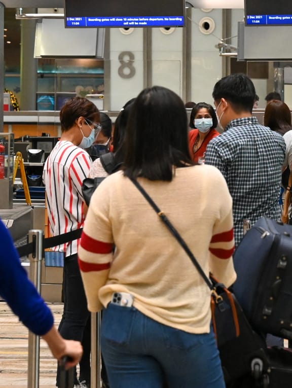 Travellers checking in for a flight at the Singapore Airlines counter in the departure hall of Changi Airport on Dec 2, 2021.