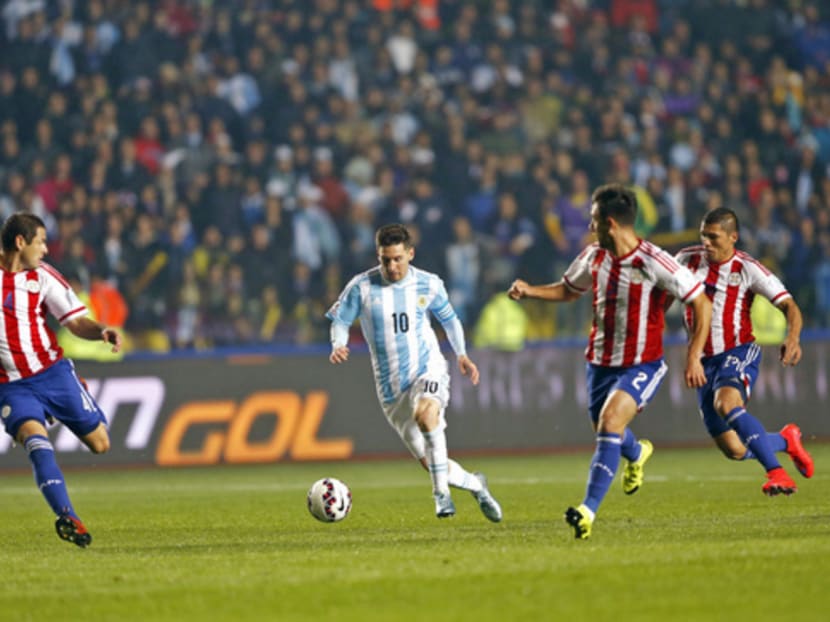 Argentina’s Lionel Messi (centre) running with the ball through the Paraguay defence during the Copa America semi-final match. Photo: AP
