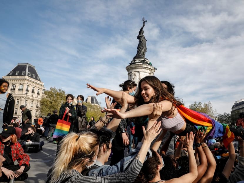 A woman crowd surfs as people gather at the Place de la Republique in Paris on April 25, 2021 for a rally called for "the visibility of lesbians" and "medically assisted reproduction for all".