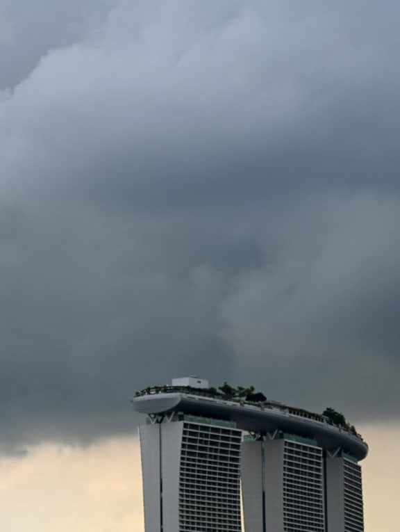 Rain clouds hovers over the Marina Bay Sands hotel and resorts building in Singapore on July 25, 2022.