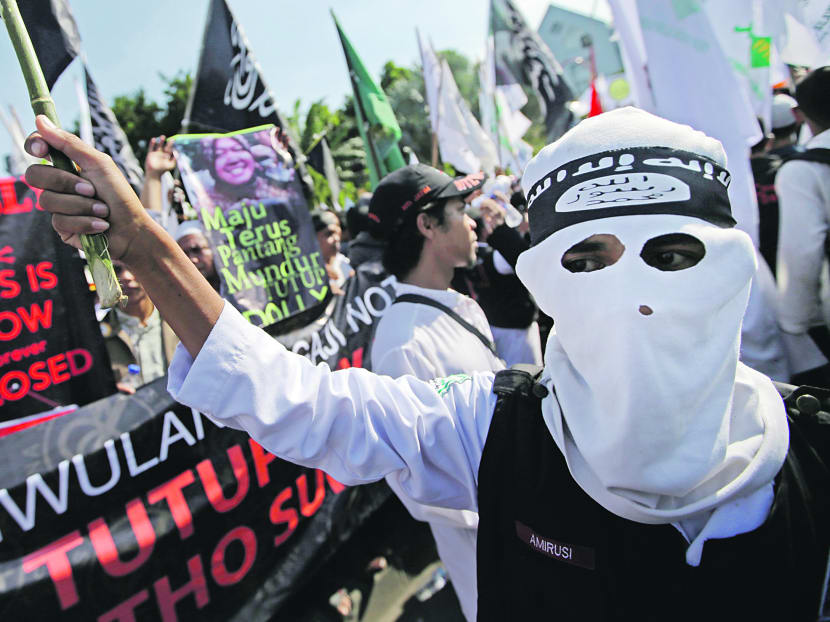 A man wearing a headband showing the Islamic State group’s symbol during a protest in Surabaya in June last year. AP file photo