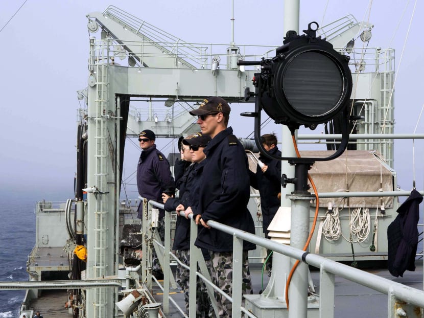 Crew members of the Australian Navy ship, HMAS Success, look out from the deck after a potential sighting was reported in the southern Indian Ocean during the search for missing Malaysian Airlines flight MH370 in this picture released by the Australian Defence Force March 25, 2014. Photo: Reuters