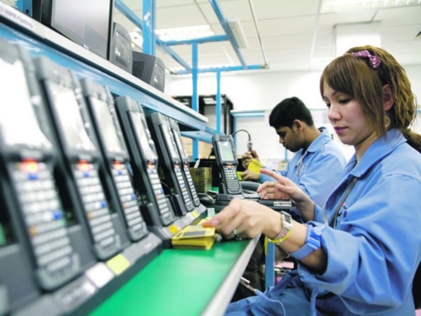 Workers test hand-held inventory computer devices on an assembly line at a factory in Singapore. Photo: Bloomberg