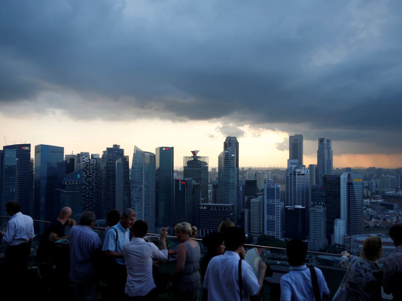 Tourists have drinks at a hotel rooftop bar as clouds gather over the central business district in Singapore on June 6, 2016. Photo: Reuters