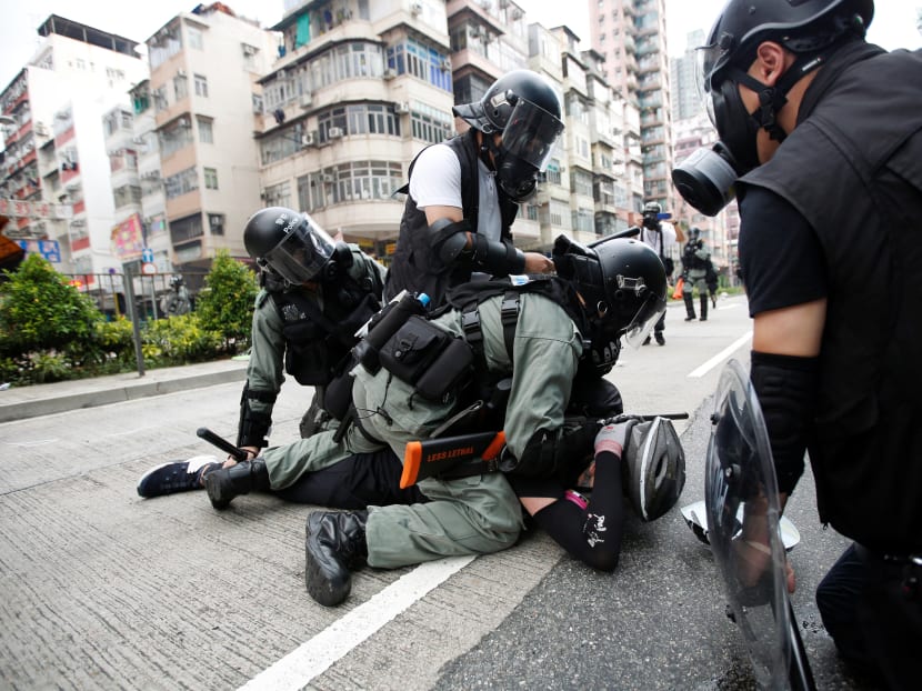 Police officers subdue an anti-government protester near Sham Shui Po police station in Hong Kong on Aug 11, 2019.