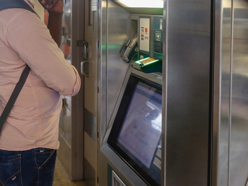 A commuter topping up the stored value of his fare card at a machine.