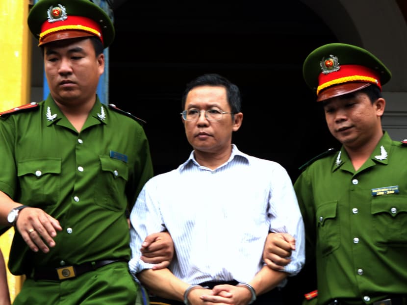 French-Vietnamese blogger and lecturer Pham Minh Hoang (centre) being led out from the courtroom at the Ho Chi Minh City People's Court House after he was jailed for three years for attempted subversion, on Aug 10, 2011.