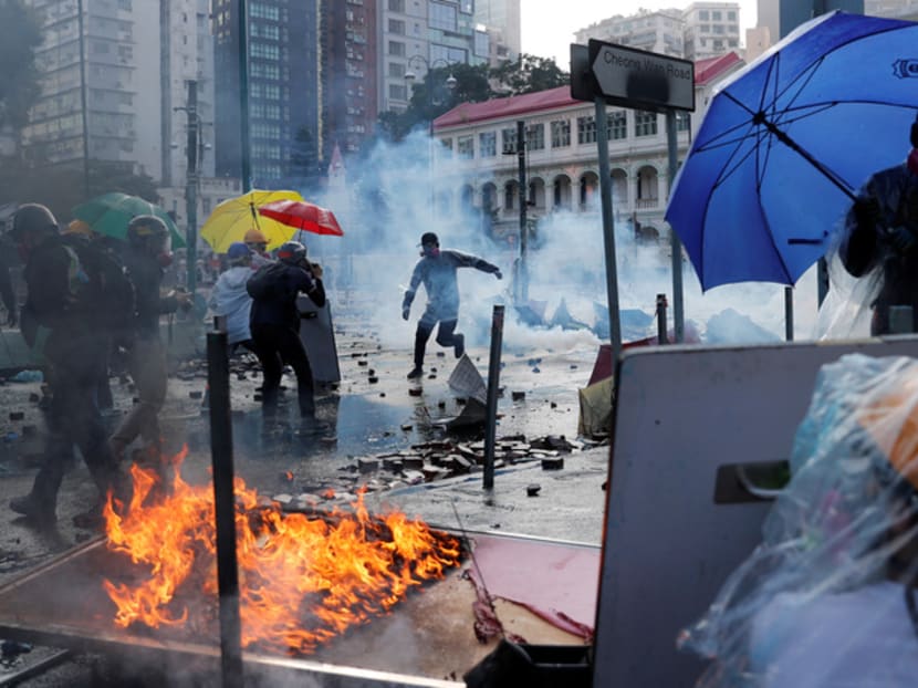 Anti-government protesters take cover during clashes with police, outside Hong Kong Polytechnic University in Hong Kong on Nov 17. Anti-government protesters take cover during clashes with police, outside Hong Kong Polytechnic University in Hong Kong on Nov 17.
