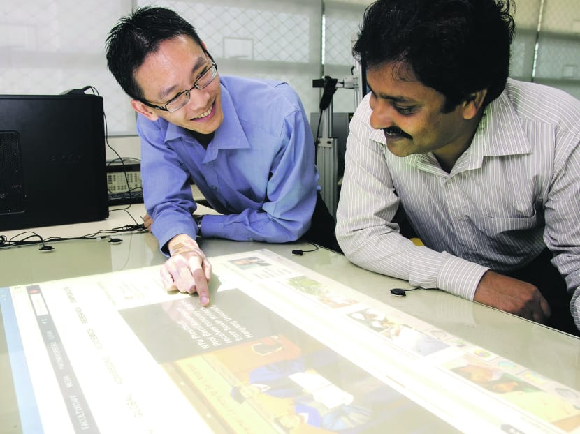 Asst Prof Andy Khong and Research Fellow V G Reju using their prototype mounted on glass. Photo: Nanyang Technological University