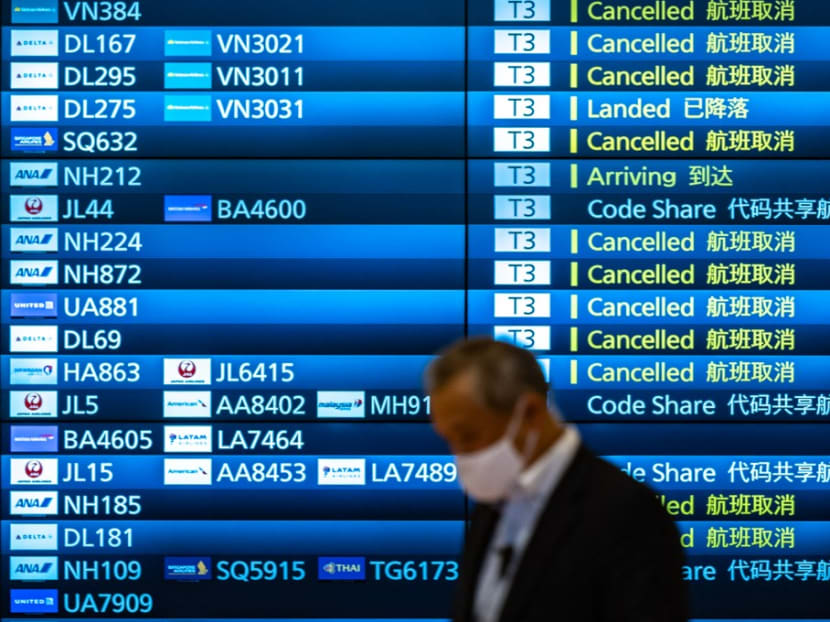A man walks past an arrivals board showing cancelled flights at Tokyo's Haneda international airport on Nov 30, 2021.