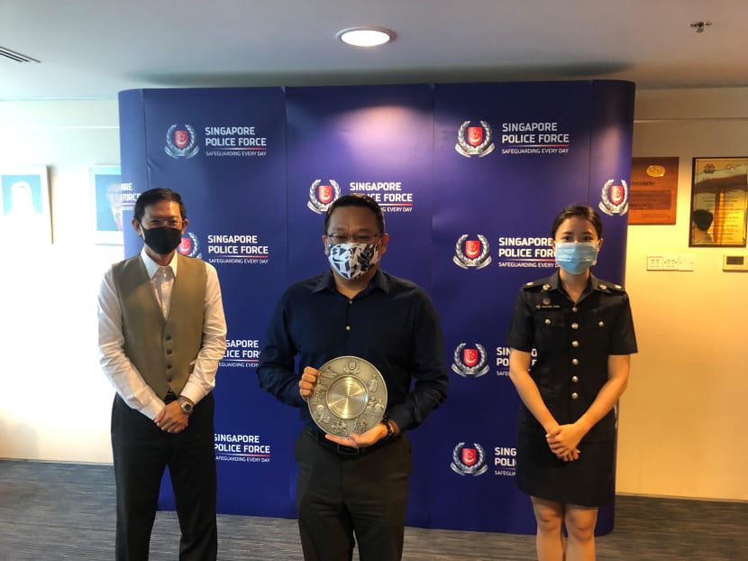 Mr David Chew (first from left) of the police's Commercial Affairs Department and Assistant Superintendent of Police Geraldine Cheng (first from right) from the Anti-Scam Centre present Mr Richard Soh of United Overseas Bank's integrated fraud management arm with a community partnership award on Oct 8, 2020.
