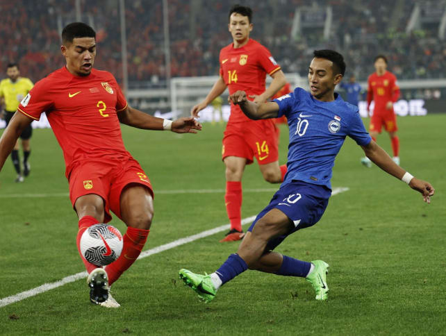 Singapore's Faris Ramli (in blue) in action with China's Jiang Guangtai during the 2026 FIFA World Cup qualifier at the Tianjin Olympic Center, Tianjin, China on March 26, 2024.
