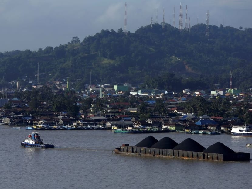 A tug boat pulls a coal barge along the Mahakam River in Samarinda, East Kalimantan province, Indonesia.