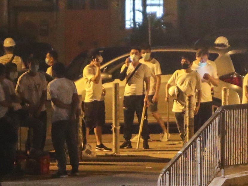 Men wearing white T-shirts and wielding weapons stand on the streets of Yuen Long on Sunday night (July 21), which descended into mob violence.