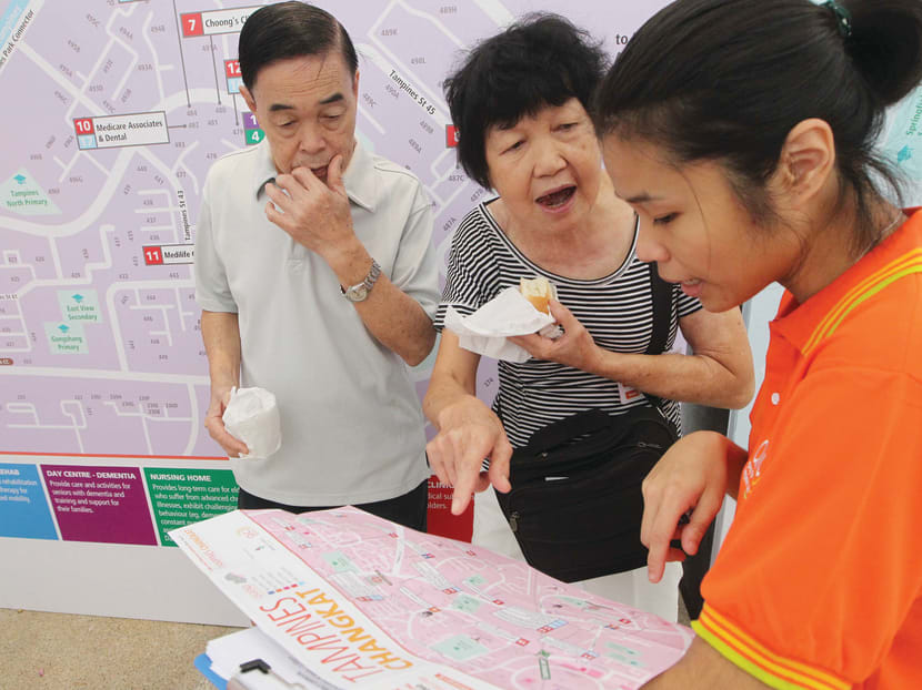 An Agency for Integrated Care staff (right) explaining how a ‘localised’ map — a pilot scheme designed to help residents locate the right services for their healthcare needs in Tampines — works during the CHAS Family Carnival at Tampines Community Plaza yesterday. Photo: Ooi Boon Keong