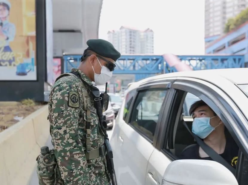 An Armed Forces personnel conducts checks on a vehicle during a roadblock in Petaling Jaya on April 1, 2020.