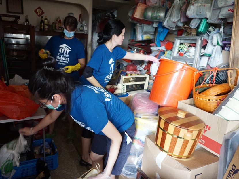 Volunteers from Habitat for Humanity Singapore doing home improvements, which include decluttering, repainting and placing of broken furniture.