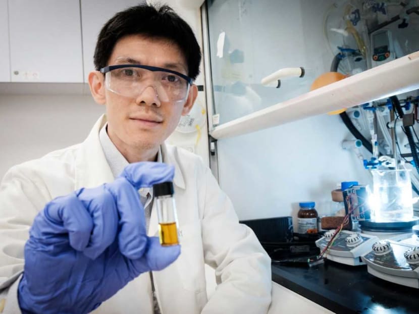Asst Prof Soo Han Sen, from NTU’s School of Physical and Mathematical Sciences, holds a vial with a mixture that dissolves plastic when combined with sunlight.