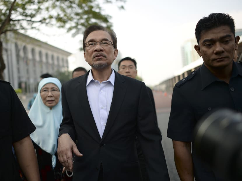 Malaysian opposition leader Anwar Ibrahim walks with his wife Wan Azizah as they arrive for his final hearing of his sodomy conviction in Putrajaya, Malaysia, Oct 28, 2014. Photo: AP