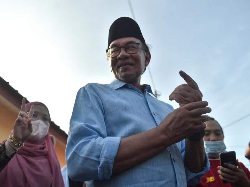Malaysia’s opposition leader Anwar Ibrahim, chairman of the Pakatan Harapan (Alliance of Hope), shows his inked finger after voting at a polling station during the general election in Permatang Pauh, Malaysia's Penang state, on Nov 19, 2022. 
