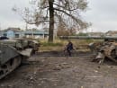 FILE PHOTO - A local resident rides a bicycle past abandoned Russian tanks in the village of Kurylivka, amid Russia's attack on Ukraine, in Kharkiv region, Ukraine October 1, 2022.  REUTERS/Vitalii Hnidyi