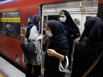 Iranian women wearing face masks enter and exit a women-only train carriage at a metro station in the capital Tehran on June 10, 2020 amid the coronavirus Covid-19 pandemic crisis.