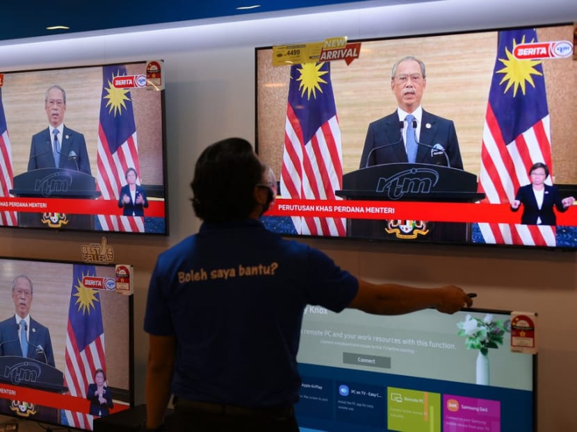 A man watches a television on display at a shopping mall store as Malaysian prime minister Muhyiddin Yassin announces his resignation as he addresses the nation during a live telecast in Kuala Lumpur on Monday, Aug 16, 2021.
