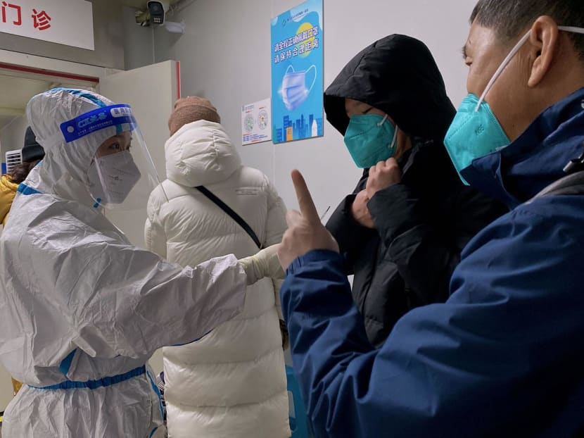 A health worker talks to people at a fever clinic of the First Affiliated Hospital of Chongqing Medical University amid the Covid-19 pandemic in China's southwestern city of Chongqing on Dec 22, 2022.
