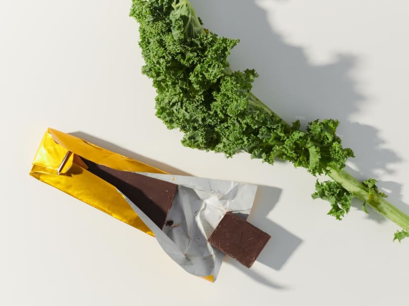 <p>A chocolate bar and a piece of kale in Los Angeles on July 7, 2022. Studies suggest that cocoa might benefit health, but it’s unclear how that may translate to a typical bar of chocolate.</p>
