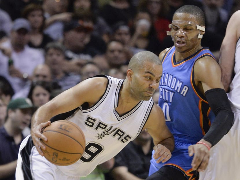 San Antonio Spurs guard Tony Parker, left, of France, drives around Oklahoma City Thunder guard Russell Westbrook during the first half of an NBA basketball game, Wednesday, March 25, 2015, in San Antonio. (AP Photo/Darren Abate)