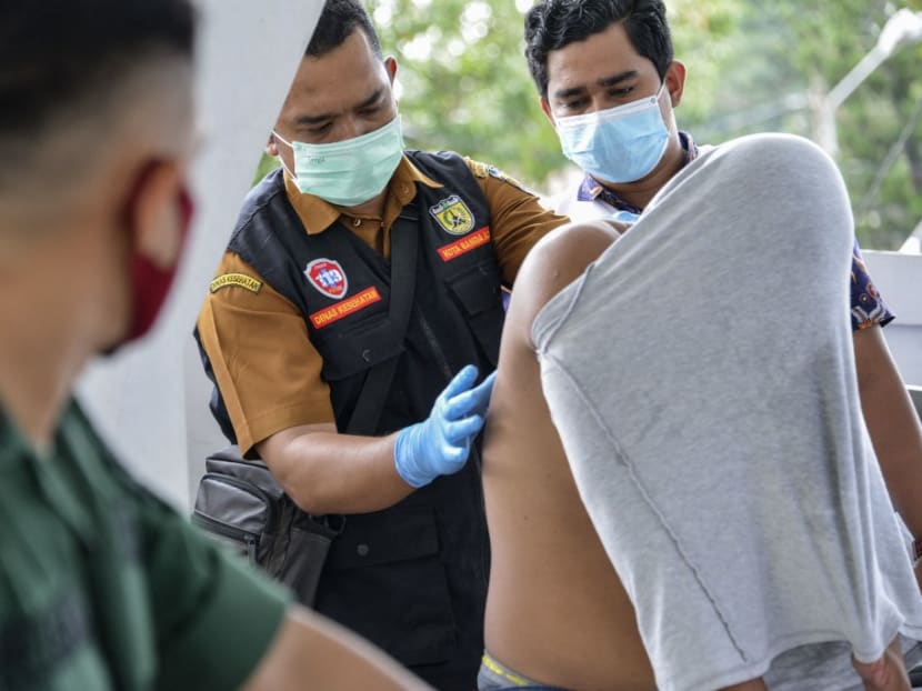 Medical workers treat a Christian man's wounds on his back after being flogged by a member of the Sharia police for being caught gambling in Banda Aceh on Feb 8, 2021.