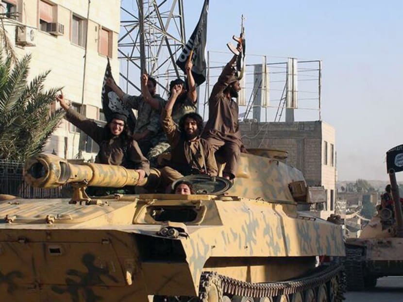 In this undated image posted by the Raqqa Media Center, in Islamic State group-held territory, on Monday, June 30, 2014, which has been verified and is consistent with other AP reporting, fighters from the al-Qaida linked Islamic State of Iraq and the Levant (ISIL) ride tanks during a parade in Raqqa, Syria. Photo: AP