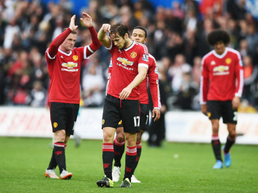 Daley Blind is dejected, while Wayne Rooney (left) applauds fans after a Swansea defeat. Photo: Getty Images