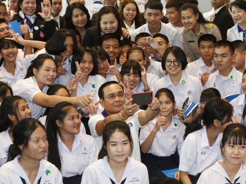 Thai Prime Minister Prayuth Chan-ocha takes a selfie with students in Nonthaburi on Dec 9 at an event to mark International Anti-Corruption Day. 