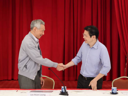 Prime Minister Lee Hsien Loong shaking the hand of Deputy Prime Minister Lawrence Wong at a press conference on April 16, 2022.
