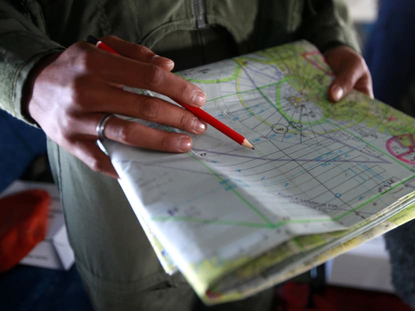 A military officer working on a map onboard a Royal Malaysian Air Force CN235 aircraft during a Search and Rescue operation to find the missing Malaysia Airlines flight MH370, in the Straits of Malacca, yesterday. Photo: Reuters