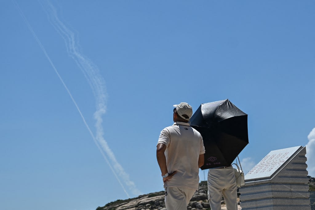 Smoke trails from projectiles launched by the Chinese military are seen in the sky as tourists look on from Pingtan Island, one of mainland China's closest point from Taiwan, in Fujian province on Aug 4, 2022. Smoke trails from projectiles launched by the Chinese military are seen in the sky as tourists look on from Pingtan Island, one of mainland China's closest point from Taiwan, in Fujian province on Aug 4, 2022.