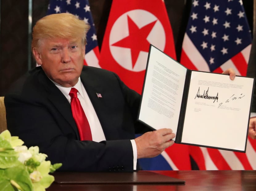 US President Donald Trump shows the document, that he and North Korea's leader Kim Jong-un signed at their summit in Singapore.