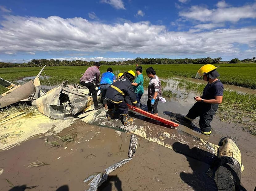 Rescuers retrieving a body from a crashed plane in Pilar, Bataan, where two Philippine air force aviators were killed.
