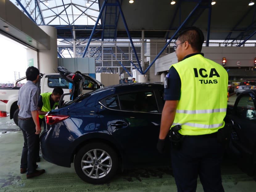 ICA officers perform security check on vehicles entering Tuas checkpoint on Dec 13, 2017. Photo: Najeer Yusof/TODAY