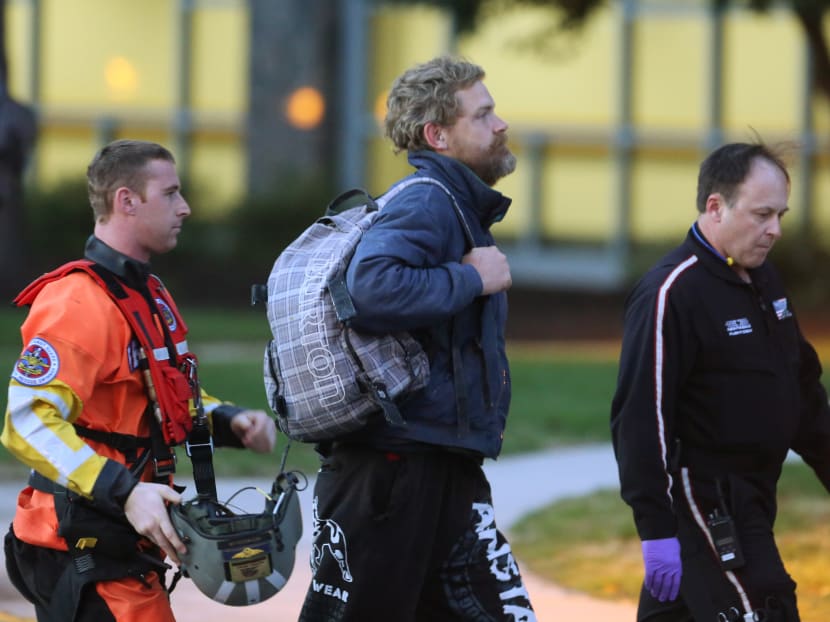 Mr Louis Jordan (centre) walks from the Coast Guard helicopter to the Sentara Norfolk General Hospital, after being found off the North Carolina coast. Photo: AP