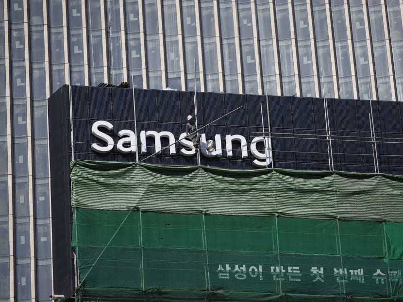 A worker works on a Samsung outdoor advertisement installed atop an office building in central Seoul March 23, 2015. Photo: Reuters