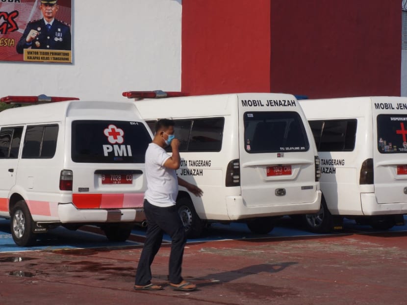 A man walks past ambulances that will transport the bodies of victims outside the prison in Tangerang on Sept 8, 2021, after a fire broke out and killed 41 inmates.