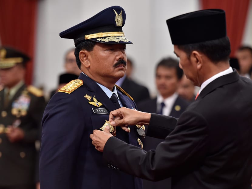 Indonesian President Joko Widodo attaches the rank to the new Armed Forces Chief Marshall Hadi Tjahjanto during an inauguration ceremony at the Presidential Palace in Jakarta last year. The new chief has signaled the military is set to fall in behind Mr Widodo at a critical juncture for Indonesia. Photo: Reuters via Antara News