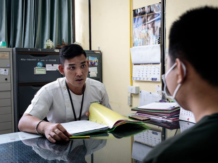 This picture taken on December 8, 2020 shows rehabilitation psychologist Shaowpicha Techo (L) speaking with former meth user Chai (a pseudonym used to protect his identity) during a check-up at Bangkok Health Centre's Khlong Toei clinic in Bangkok.