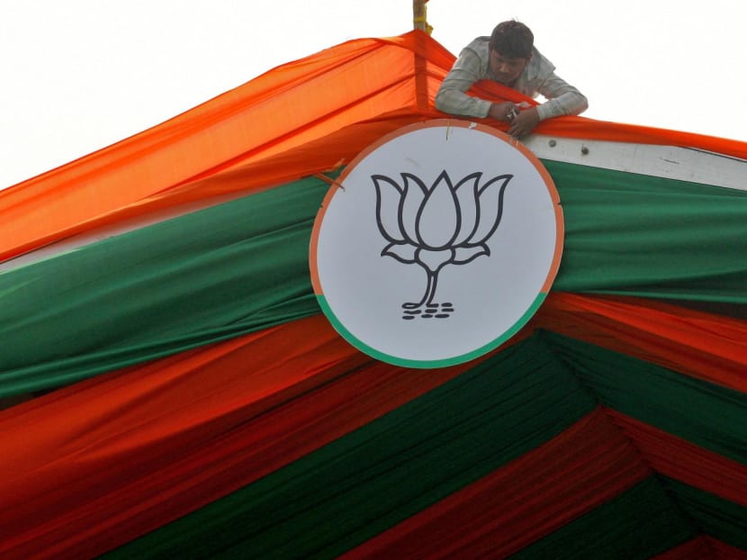 A man installs the symbol of India's ruling Bharatiya Janata Party (BJP) on a tent during an election campaign rally by the party in Prayagraj, India on Feb 24, 2022.
A man installs the symbol of India's ruling Bharatiya Janata Party (BJP) on a tent during an election campaign rally by the party in Prayagraj, India on Feb 24, 2022.