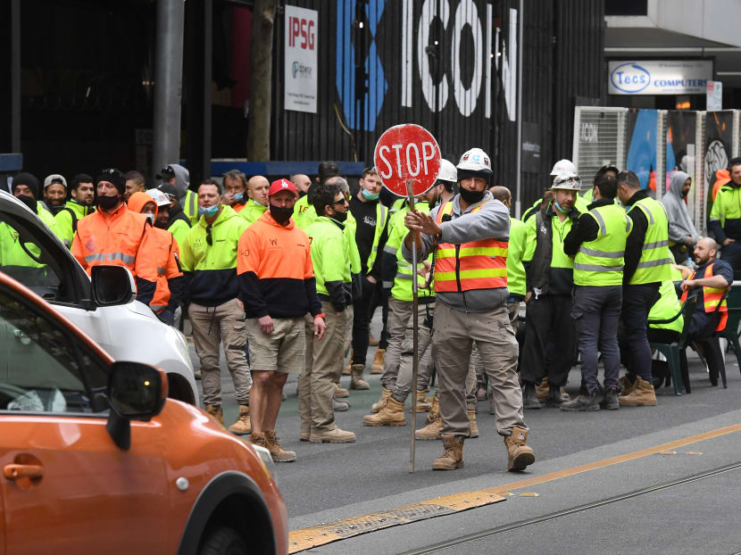 Construction workers in high-visibility vests take their lunch break on a busy street, disrupting traffic in Melbourne on Sept 17, 2021, to protest the closing of their onsite tea rooms by health officials amid growing Covid-19 clusters linked to the construction industry. Construction workers in high-visibility vests take their lunch break on a busy street, disrupting traffic in Melbourne on Sept 17, 2021, to protest the closing of their onsite tea rooms by health officials amid growing Covid-19 clusters linked to the construction industry.