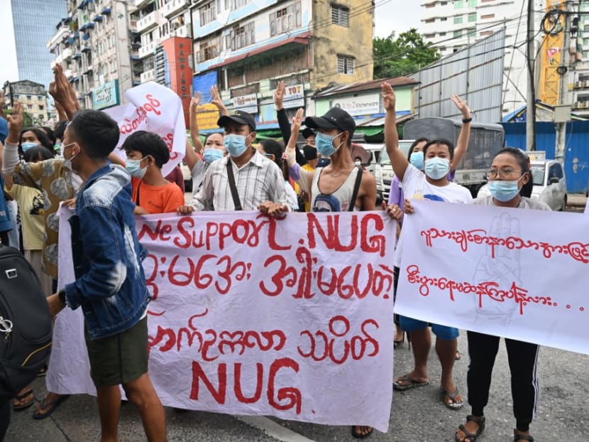 Protesters hold a banner supporting the National Unity Government (NUG) during a demonstration against the military coup in Yangon on July 11, 2021.